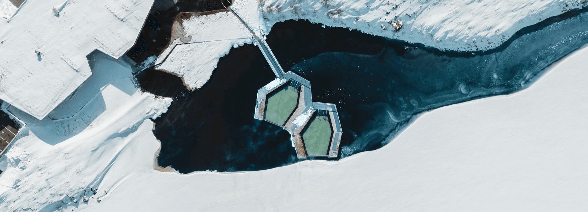 The floating pools and walkway against snow and dark lake water