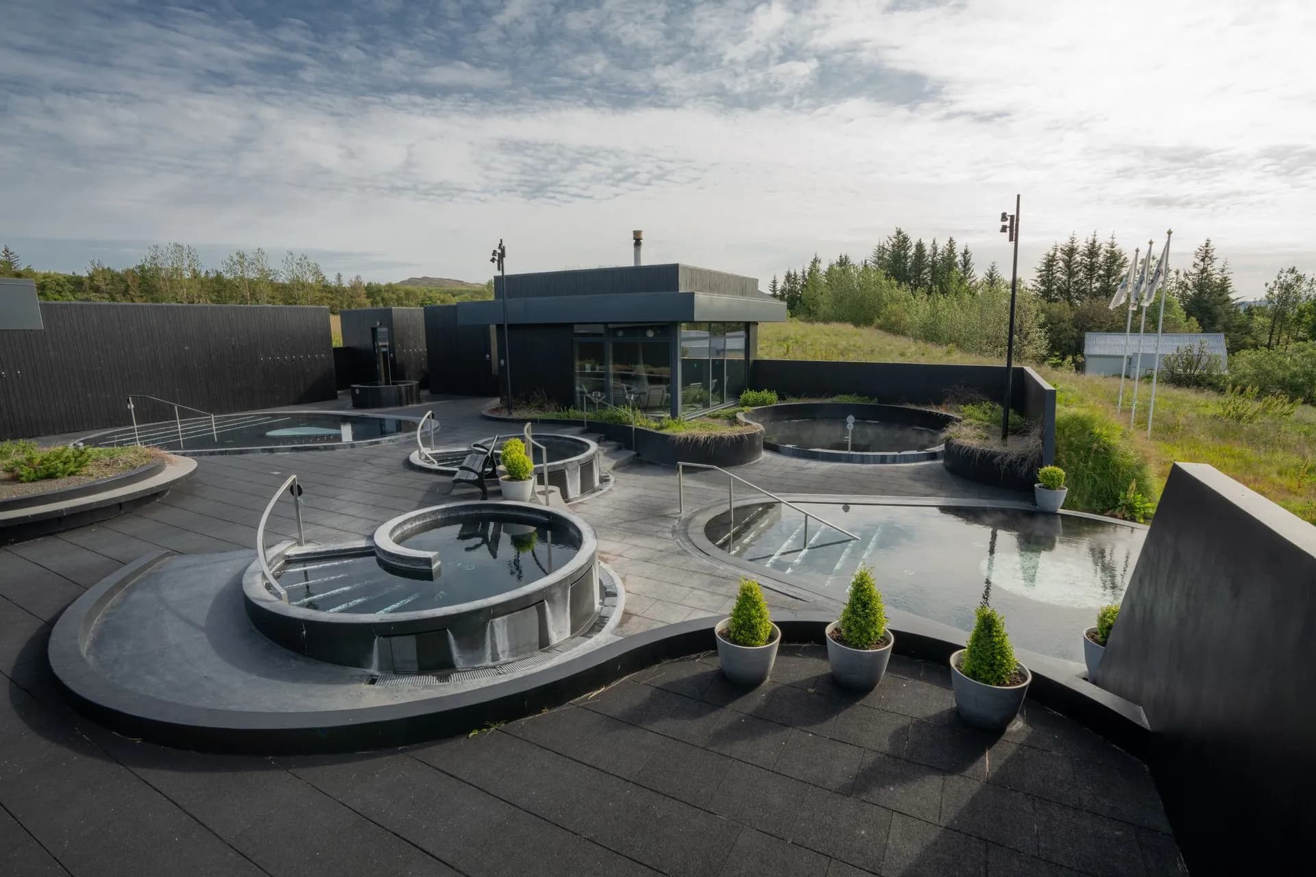 Outdoor pools in daylight with steam and a fire feature