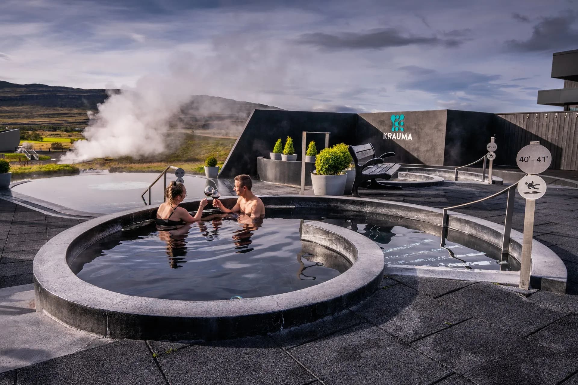 Krauma’s circular outdoor pools and fire pit at dusk