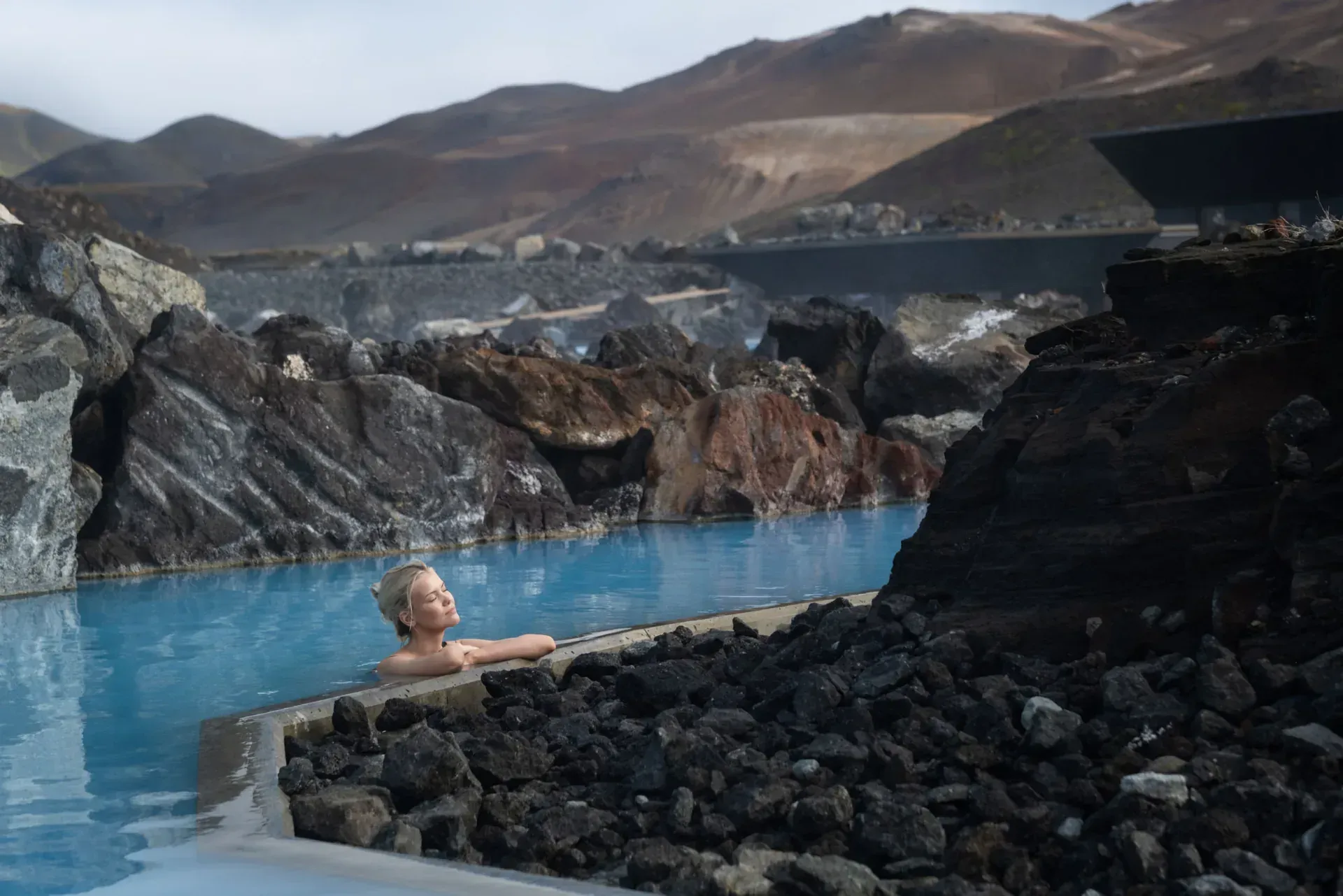 Pale-blue water winding between black lava rocks