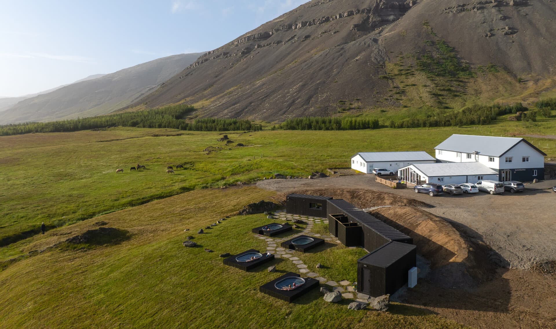 Aerial view of the Hoffell tubs and white farm buildings below the mountain